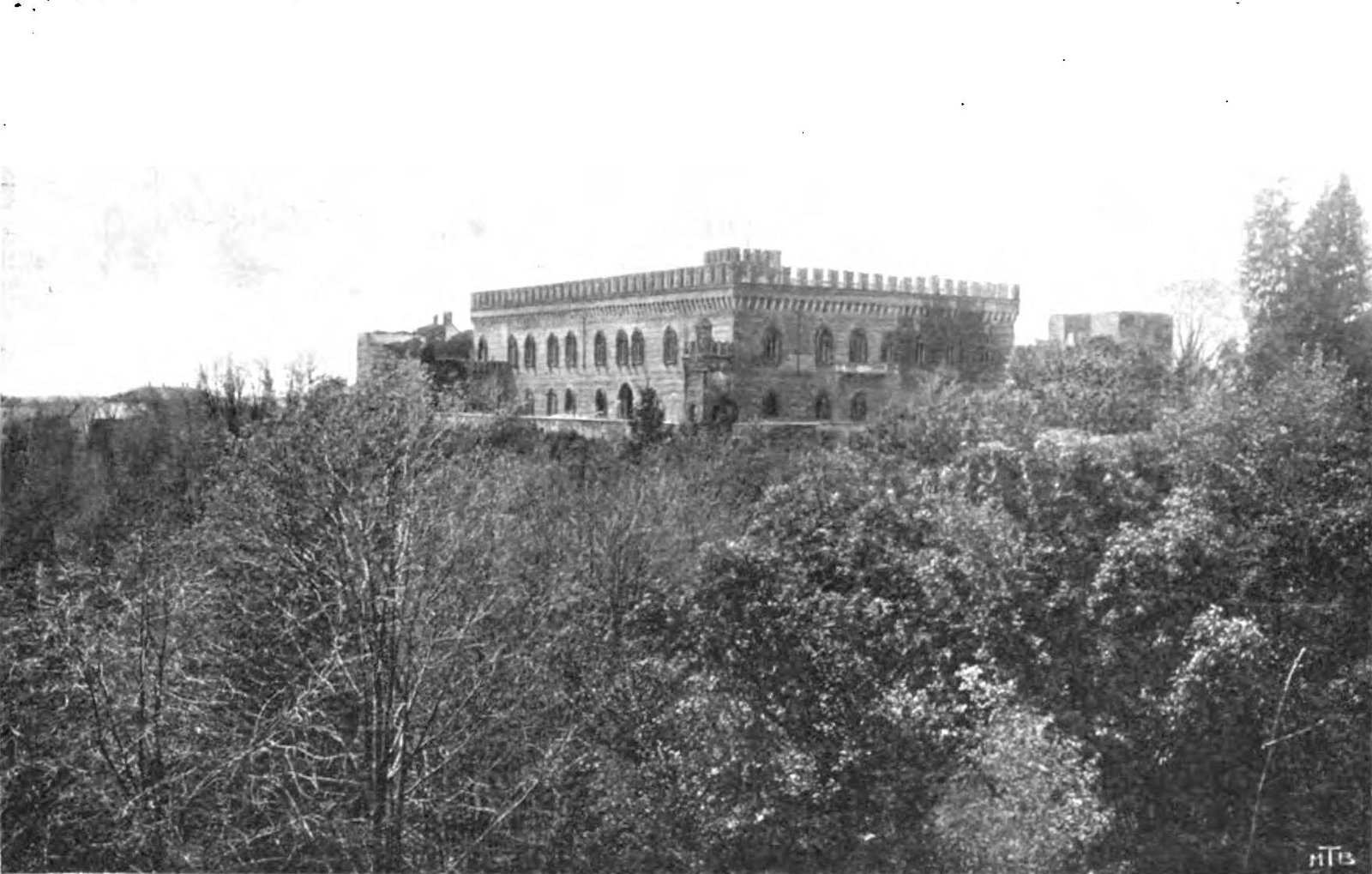Il lungo fronte merlato del Castello di Carimate, allora noto come Castello Arnaboldi, visto dal parco sopra la vegetazione, in una fotografia del volume Ville e Castelli d'Italia del 1907